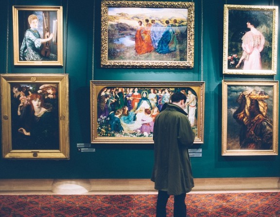 man viewing paintings in a museum: fun things to do in Dubai